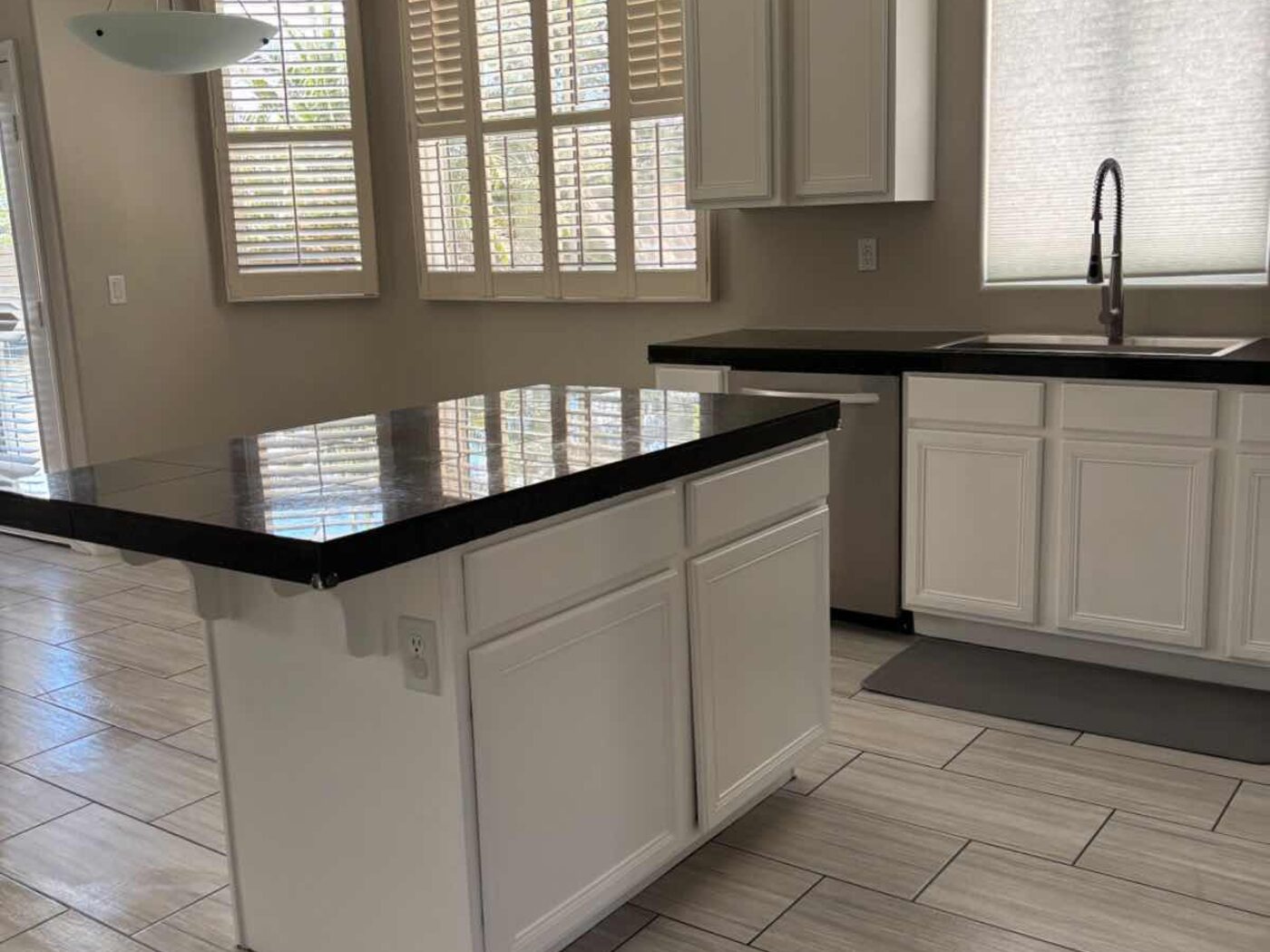 Cocina con isla y gabinetes blancos limpia y ordenada